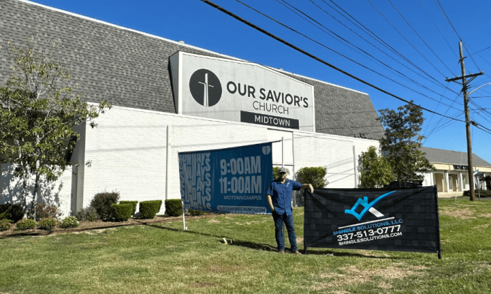 Parker standing next to shingle solutions sign