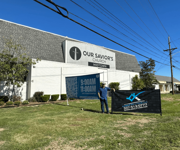 Parker standing next to shingle solutions sign